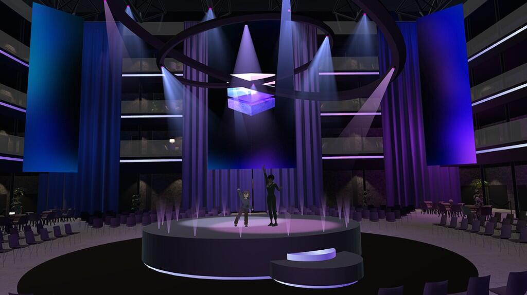 Podium in donkerblauwe en paarse verlichting met theaterstoelen daaromheen.