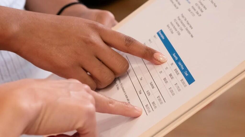 Twee handen wijzen naar tekst op een document.