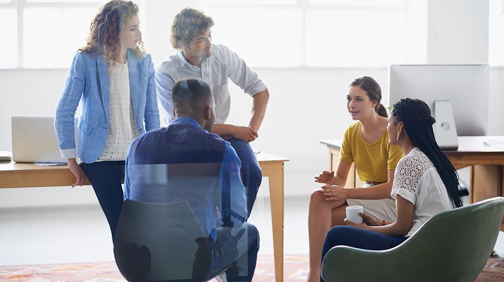 Groep mensen in bespreking in een kantooromgeving.