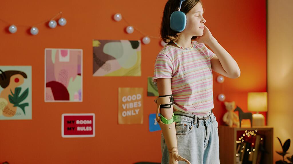 Meisje met koptelefoon en robotarm in kamer met kunst aan de muur.