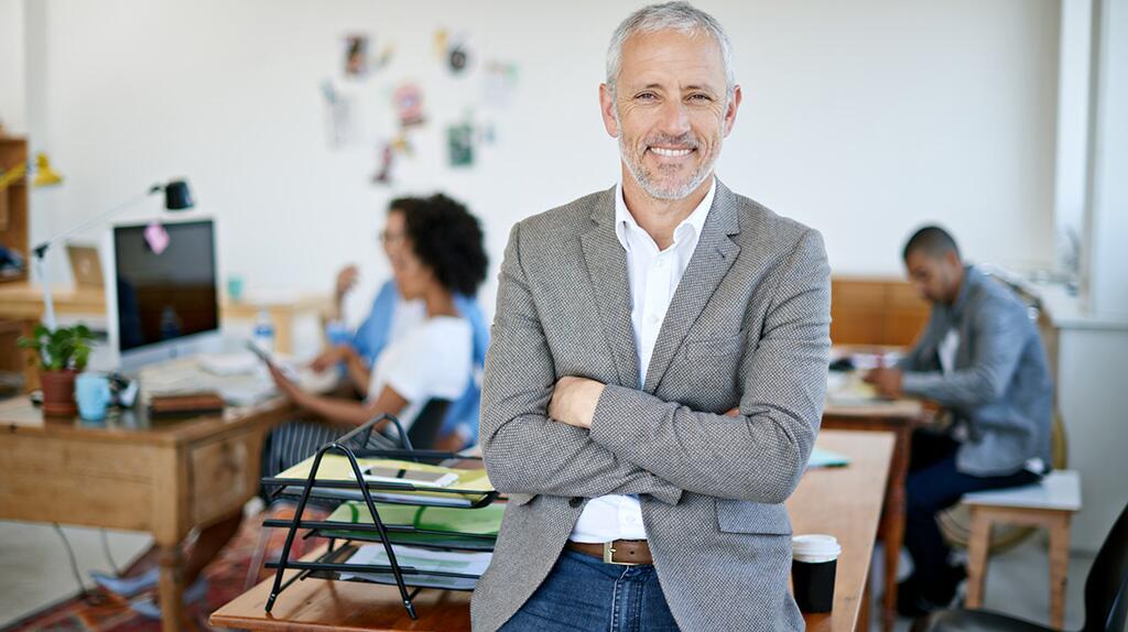 Zakelijke man glimlachend in moderne kantooromgeving.