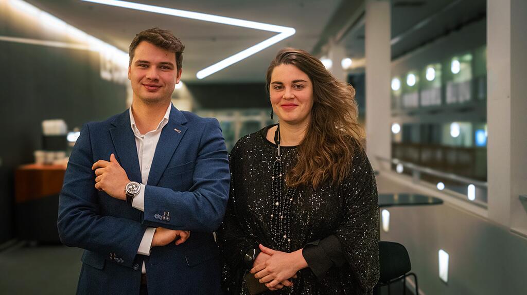 Twee mensen lachen in een moderne kantooromgeving.