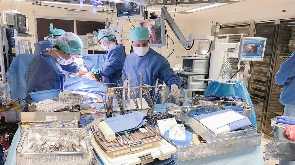 Chirurgen in operatiekamer met instrumenten en apparatuur.