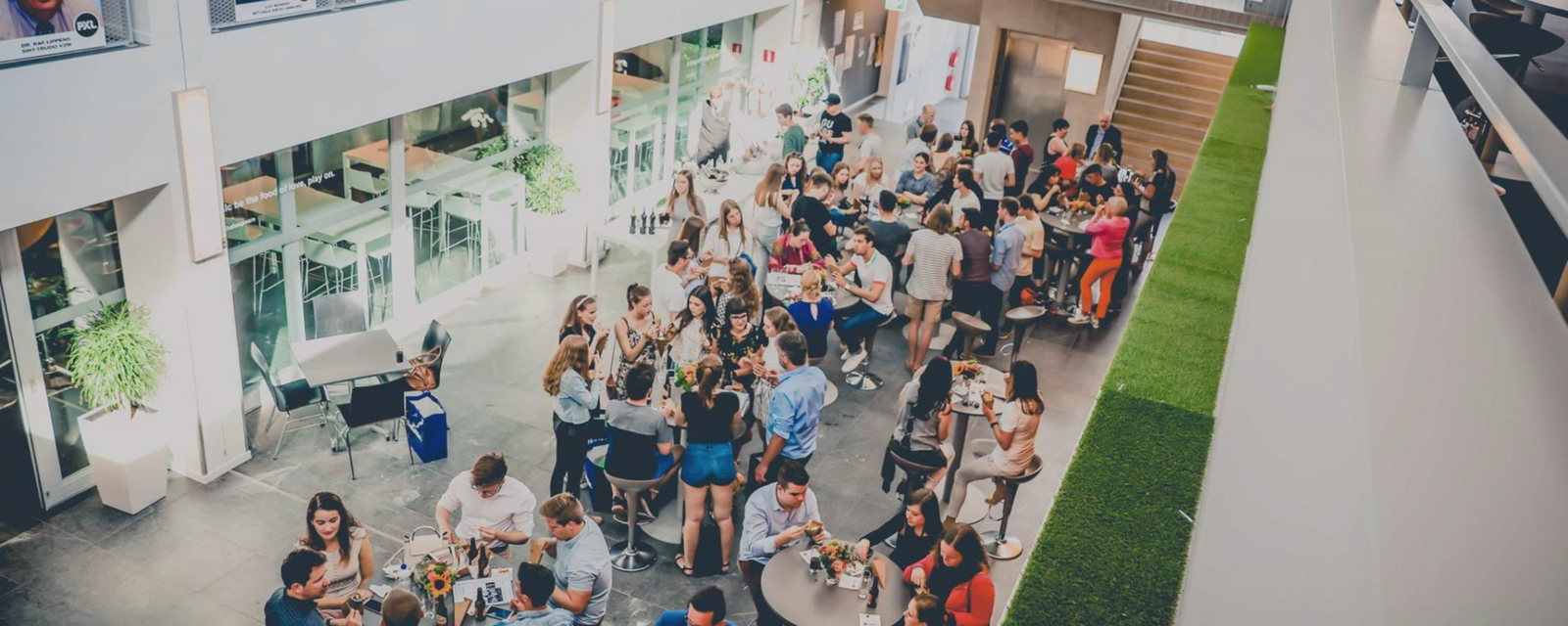 Gezellige drukte in een moderne eetzaal, mensen eten en praten aan tafels.