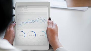 Tablet met grafieken en statistieken op scherm, vastgehouden door een persoon.