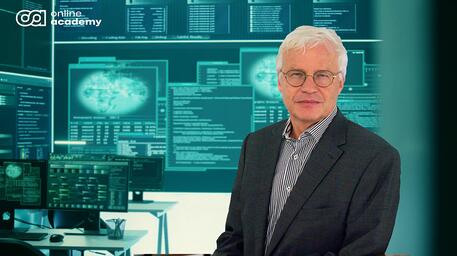 Middelbare man in pak voor computerschermen met blauwgroene grafieken en tekst.