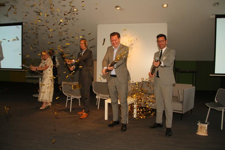 Mensen vieren een evenement met confettikanonnen in een zaal.