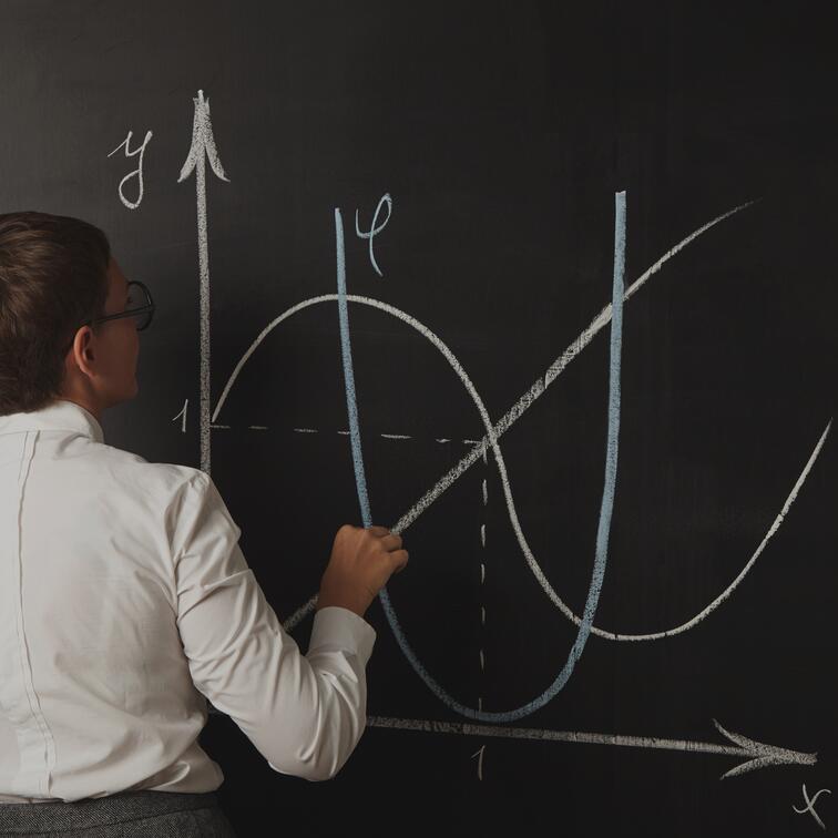 Vrouw tekent grafieken op een schoolbord.