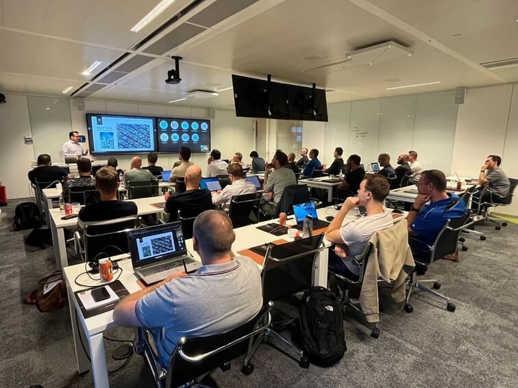 Mensen volgen een presentatie in een moderne vergaderruimte.