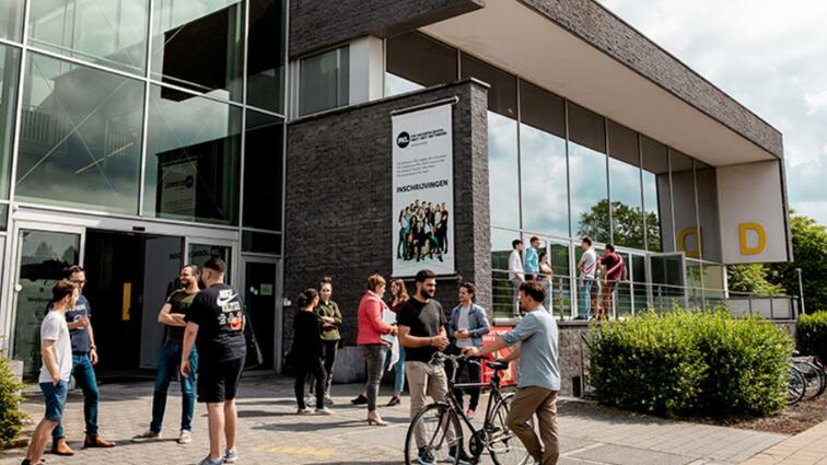 Moderne kantoorgebouw met mensen buiten, zonnige dag.